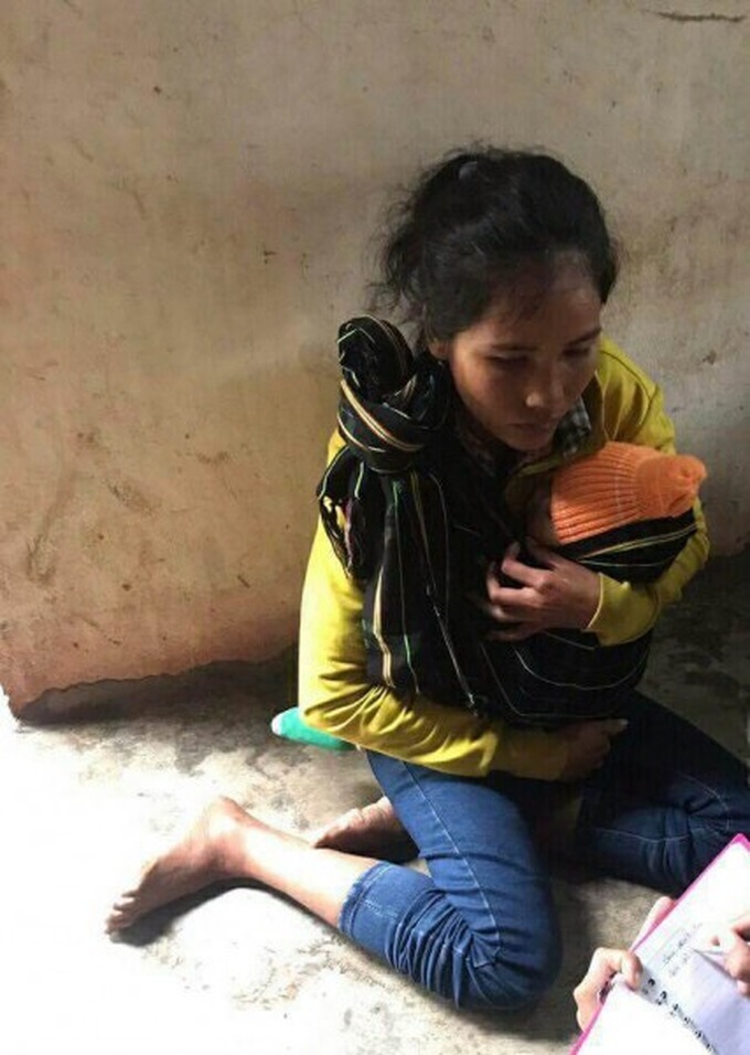 Chị H’Ria địu con ngồi thẫn thờ nơi góc nhà.