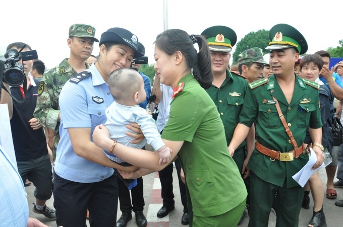 Cơ quan chức năng Trung Quốc làm thủ tục trao trẻ em bị lừa bán cho cơ quan chức năng Việt Nam. (Ảnh minh họa)