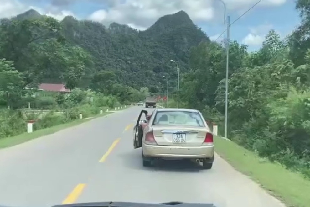 Hai vợ chồng ngồi chung ghế lái, mở cửa, lao xe trên đường - 2