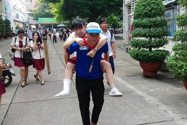 Hai nam sinh thay phiên cõng thí sinh gãy chân đi thi THPTQG