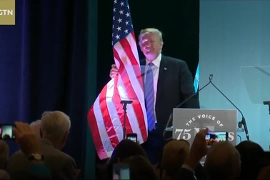 Ông Trump bất ngờ ôm chặt cờ Mỹ sau bài phát biểu về nhập cư