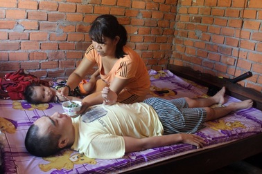 Người cha liệt tứ chi xót xa nhìn con thơ dại khát sữa