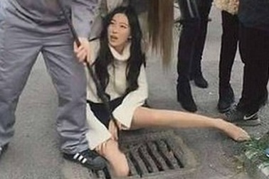 Vừa đi vừa dùng điện thoại, cô gái xinh đẹp lọt chân xuống cống