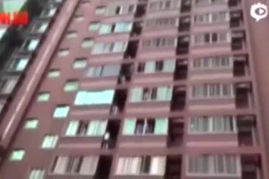 Các nhân viên cứu hộ đang cố gắng kéo người đàn ông trở ngược vào nhà