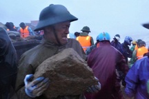 Hàng trăm người đội mưa, vật lộn với sóng dữ "vá" kè biển trong bão Bualoi