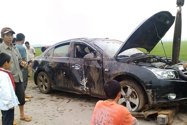 Ô tô “tắm bùn”, tài xế mắc kẹt bên trong