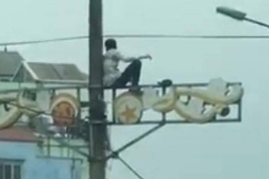 Nam thanh niên nghi ngáo đá ngồi vắt vẻo trên cột điện