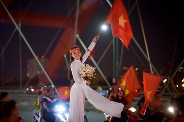 Thú vị hình ảnh thiếu nữ mặc áo dài vẫy cờ cổ vũ ĐT Việt Nam trên cầu Bình Lợi