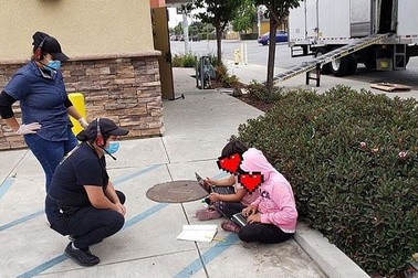 Mỹ: Hai bé gái ngồi học trên lề đường, bắt WiFi miễn phí để làm bài về nhà