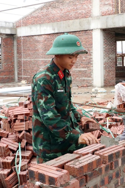 Bộ đội làm thợ xây, uốn sắt trên công trình trường liên cấp