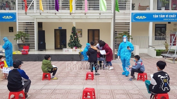 Học sinh Trường Tiểu học Đông Thành (phân hiệu 2) xếp hàng chờ lấy mẫu xét nghiệm. Ảnh Báo Bắc Giang