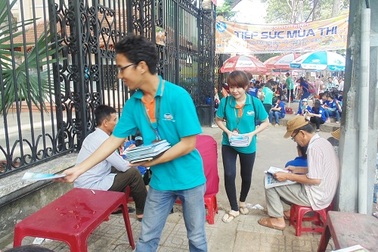 Phụ huynh chờ con thi, mỏi tay nhận tờ rơi 