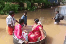 Cô dâu, chú rể ngồi trong nồi để "bơi" qua đường phố ngập lụt