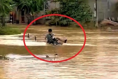 Bé trai bị nước lũ cuốn trôi khi đạp xe qua cầu tràn