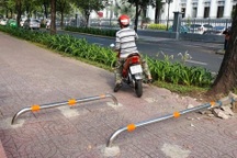 Yêu cầu tháo thanh ngăn xe máy chạy lên vỉa hè TPHCM