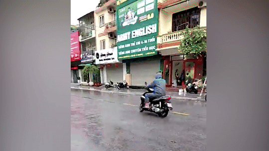 Nhiều người đi xe máy ngã sõng soài do đường đầy dầu mỡ sau mưa lớn - 1