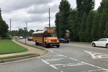 Ô tô đồng loạt dừng lại để nhường đường cho xe buýt đưa đón học sinh