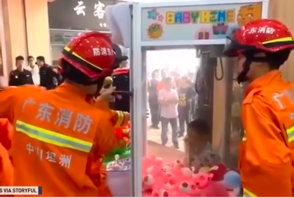 Bé 7 tuổi mắc kẹt trong máy gắp đồ chơi - 1