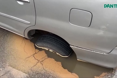 Ô tô đang đi bất ngờ bị sụp bánh xe xuống hố ở Hà Nội