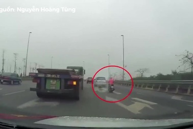 Người phụ nữ đi xe máy liều mạng tạt đầu xe container