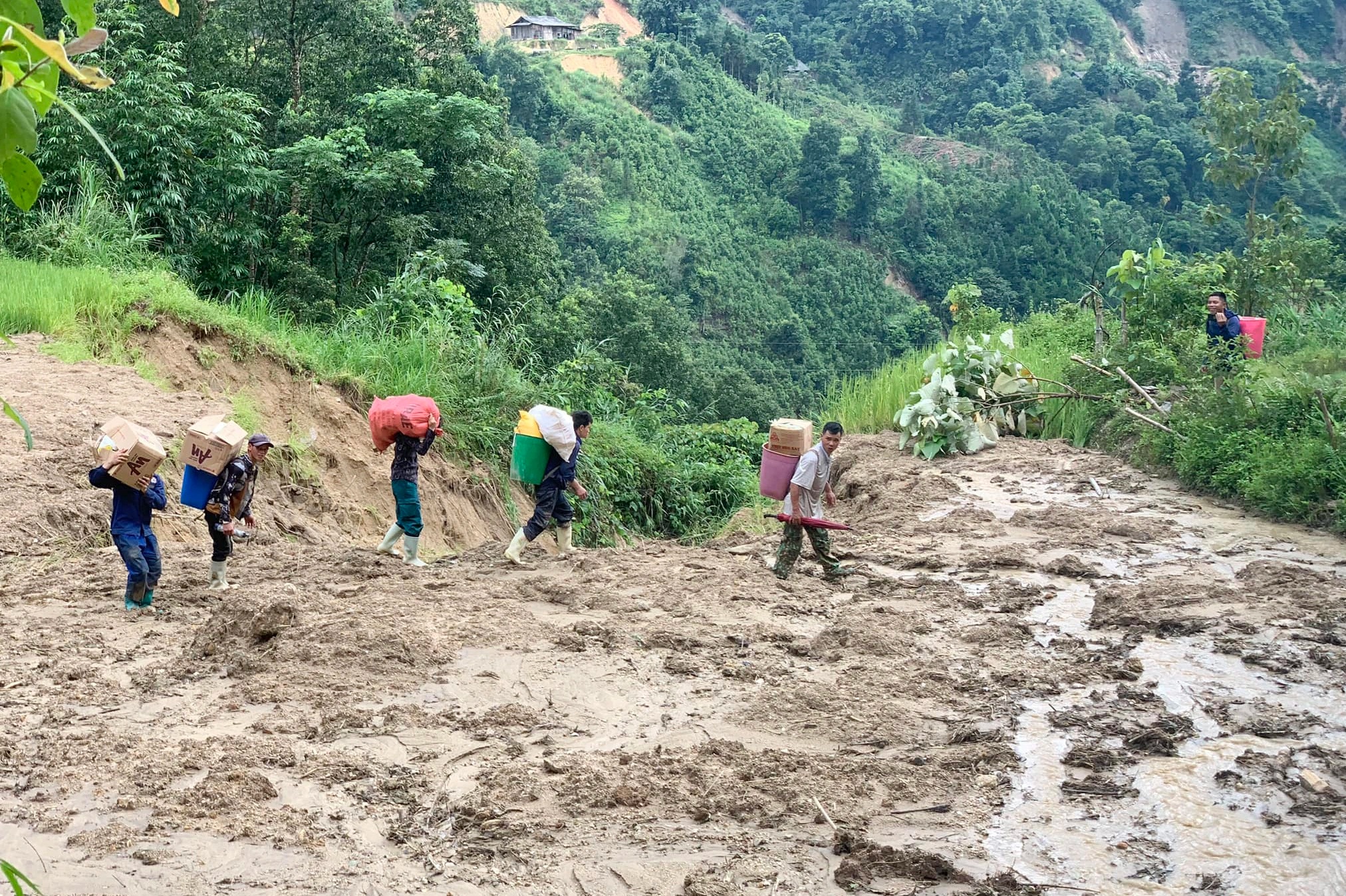 Người dân bản Liền vượt sạt lở đi nhận cứu trợ (Ảnh: Tư Hoàng).