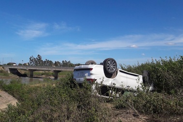 Xế hộp mất lái nằm phơi bụng dưới mép sông