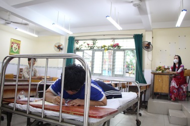 Nam sinh TPHCM nằm sấp làm bài thi tốt nghiệp THPT 2023