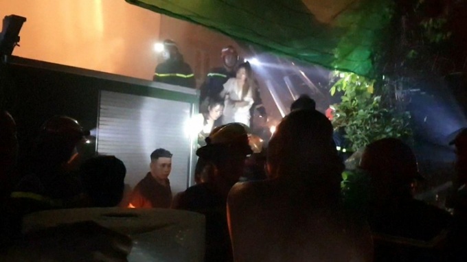 Nhân viên bị mắc kẹt bên trong quán karaoke được lực lượng chức năng đưa ra ngoài. Nguồn: PLO