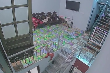 Cháu bé chui qua song lan can để xuống cầu thang