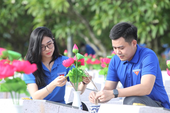 Các đoàn viên, thanh niên làm vệ sinh thay hoa tại nghĩa trang Ba Dốc