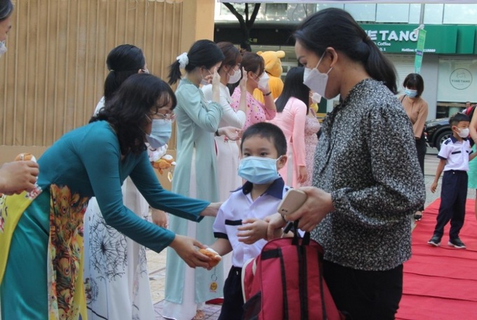 Giáo viên Trường tiểu học Nguyễn Bỉnh Khiêm TP.HCM tặng quà cho học sinh ngày tựu trường.