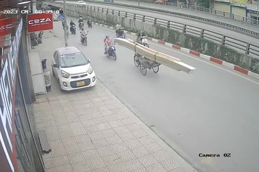 Người phụ nữ đi xe máy lao đầu vào xích lô chở gỗ cồng kềnh giữa đường