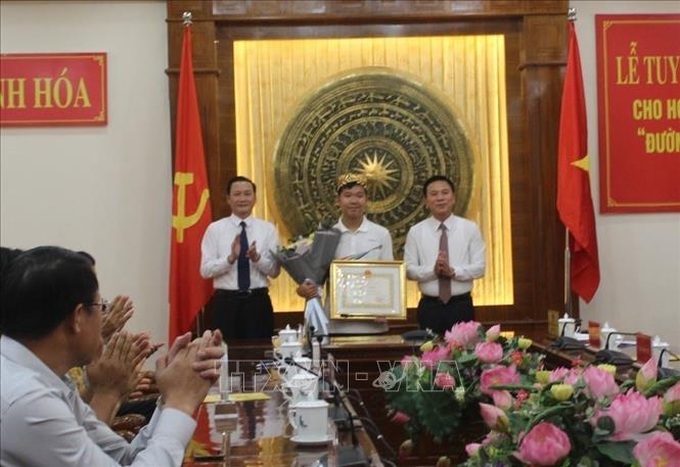 Chủ tịch UBND tỉnh Thanh Hóa trao Bằng khen và thưởng nóng 200 triệu đồng cho nhà vô địch Lê Xuân Mạnh. Ảnh: TTXVN