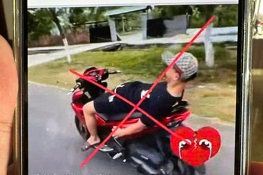 Nam thanh niên nằm ngửa trên yên thả 2 tay khi điều khiển xe máy