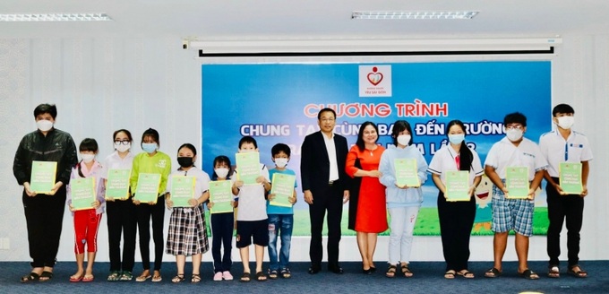 Bà Trần Thị Xuân Mai - GĐ Sở LĐ-TB&TP. Cần Thơ cùng nhà tài trợ trao sổ tiết kiệm cho các bé.