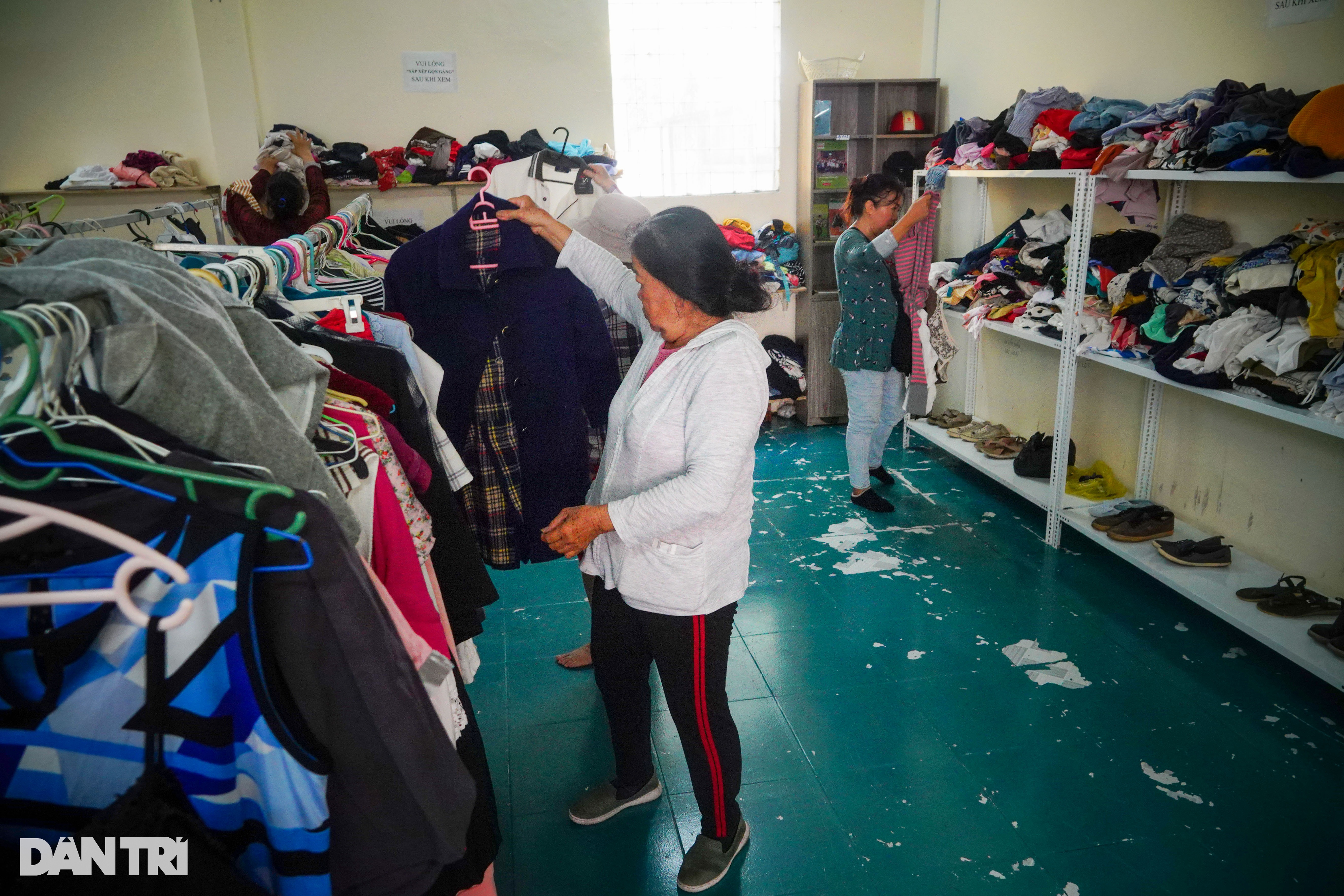 Người lao động nghèo lựa quần áo 0 đồng ở cửa hàng (Ảnh: Nguyễn Vy).