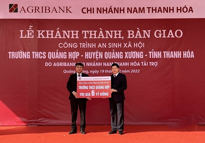 Đại diện Agribank Nam Thanh Hóa (phải) trao tượng trưng công trình an sinh xã hội Trường THCS Quảng Hợp