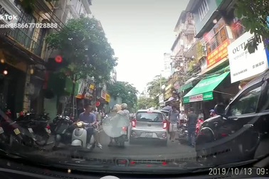 Mở cửa ô tô bất cẩn khiến người đi xe máy ngã ra đường