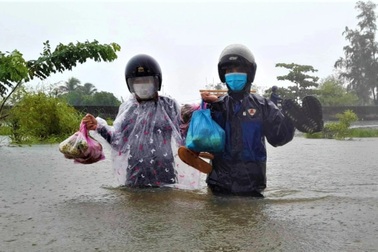 Mưa như trút, lũ dâng mênh mông, dân lội nước ngập ngang lưng về nhà