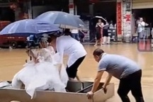 Bố vợ và chú rể đẩy thuyền đưa cô dâu về nhà chồng giữa đám cưới mùa lũ