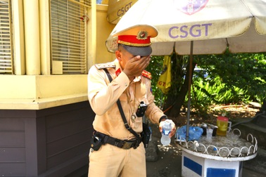 Làm việc dưới cái nắng như đổ lửa, CSGT phải liên tục dùng nước để hạ nhiệt