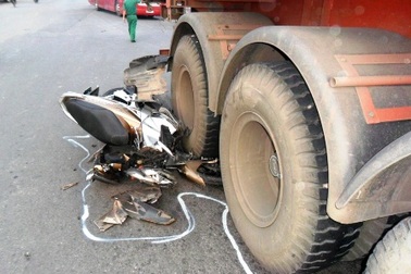 Ba mẹ con thoát chết may mắn dưới bánh xe container