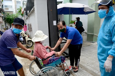 Người phụ nữ ung thư được chồng đẩy xe lăn đi xét nghiệm Covid-19