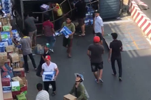 Người dân giúp tài xế gom hàng trăm thùng nước khi xe tải lật