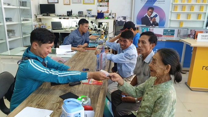 Đối tượng bảo trợ xã hội đang hưởng chính sách trợ giúp xã hội tại cộng đồng ở huyện Phú Lộc, Thừa Thiên Huế tiếp cận phương thức chi trả mới từ nhân viên Viettel (Ảnh chụp trước 27/4/2021)