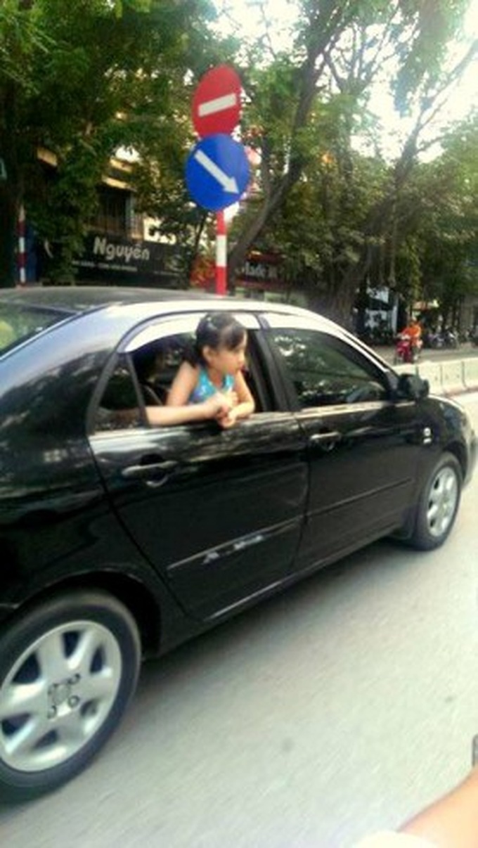 Đường đang rất đông,thế nhưng không hiểu sao bố mẹ cháu lại để cho cháu thò hẳn đầu ra khỏi cửa kính như thế này