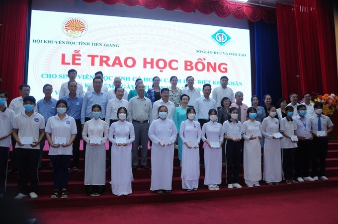 Các em sinh nhận học bổng chụp ảnh cùng đại biểu chương trình.