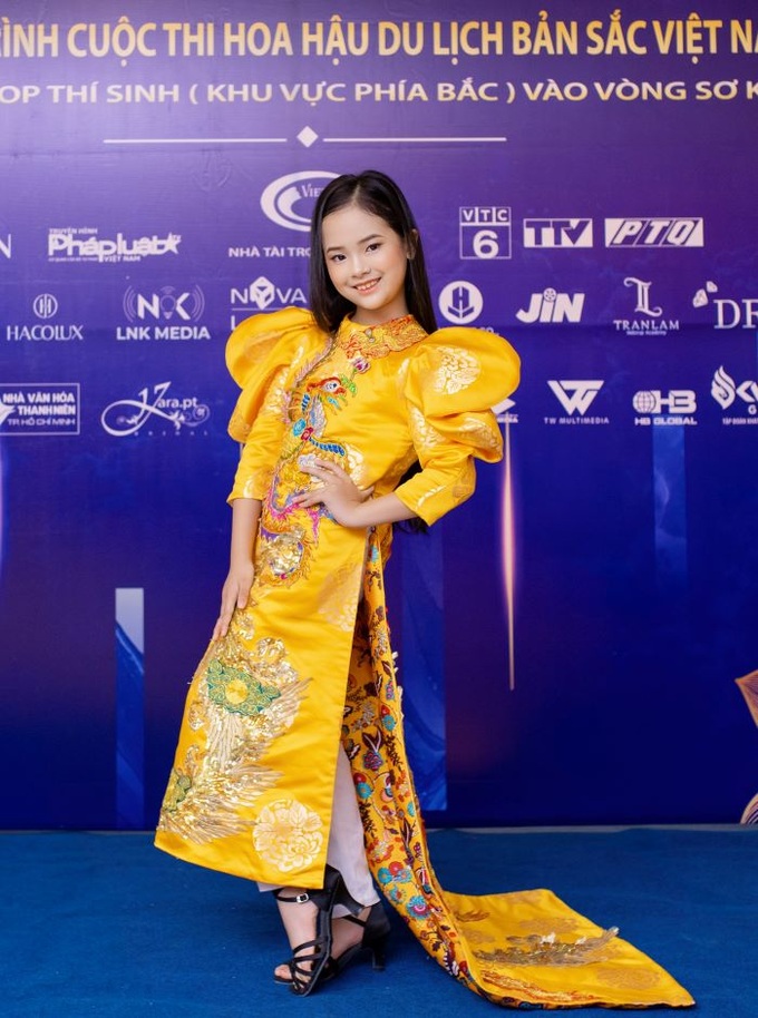 Chỉ mới 9 tuổi nhưng Gia Bảo - Quán quân Đại sứ Áo dài Trẻ em Việt Nam 2022 đã tạo dáng tự tin và thần thái trong thiết kế áo dài của NTK David Minh Đức