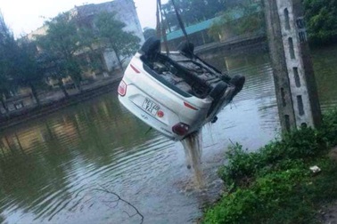 Né xe máy ngược chiều, ô tô 4 chỗ lao xuống hồ nước