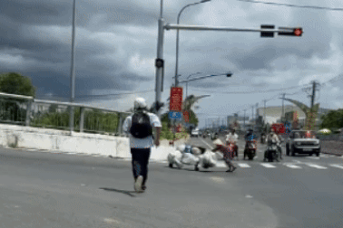 Hai nam sinh dừng xe giữa trời nắng nóng, giúp cụ bà gù lưng vượt dốc cầu